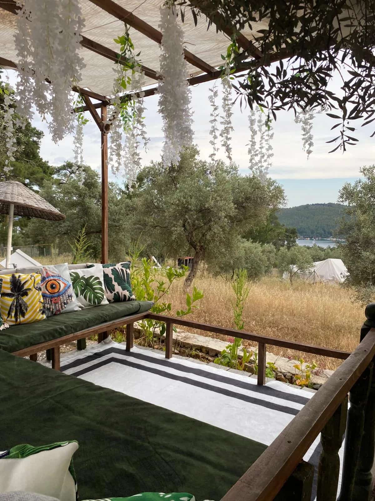 Zeytin ağaçları arasındaki deniz manzaralı kamp ve dinlenme alanı